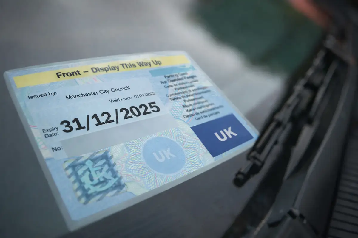 Disabled persons Blue Badge parking permit on the dashboard of a car
